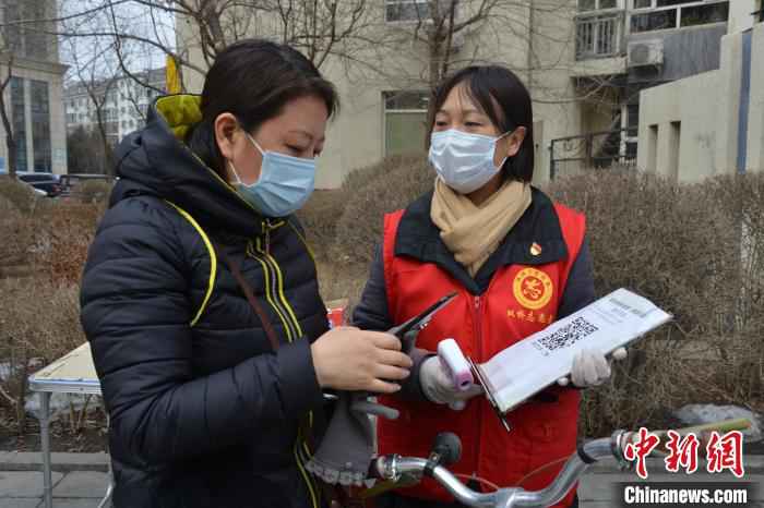 李悦为社区居民测体温,帮助居民登记扫码信息 张桂芹 摄 河北承德一社区女书记抗“疫”38天未休息:“吃点苦受点累不算啥!”